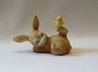 drowsy brown bunny balancing baby chick on his toe figurine