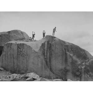  Indian Men Atop a Huge Rock Formation, Wielding Sledge 