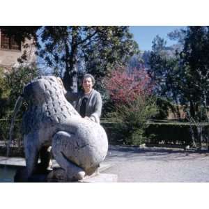  A Woman Poses Beside the Statue of a Lion at the Alhambra 