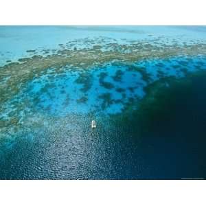  Lone Boat Floats over a Coral Reef as Seen from Helicopter 